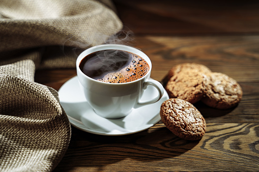 Hot coffee and cookies on a dark background