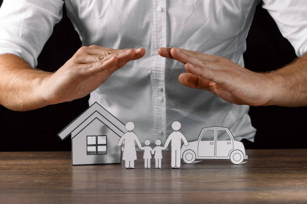 istock insurance house protection concepts, Hands post protect over house. 1073657156