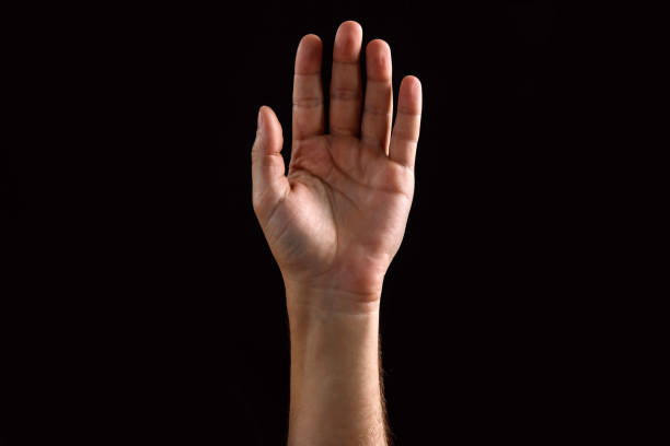 istock Male palm raised up, isolated on a dark background. Isolate 1073657246