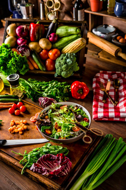 Making a vegan salad in rustic kitchen with assorted organic vegetables. Natural lighting
