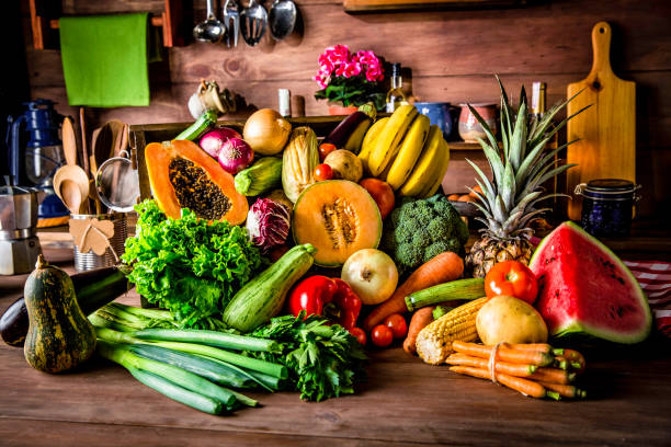 istock Rustic kitchen with ready to cut and process organic tropical fruits and vegetables. Natural lighting 1073667504