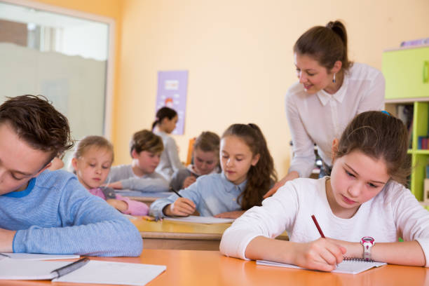 istock Teacher and pupils working in classroom 1073667864
