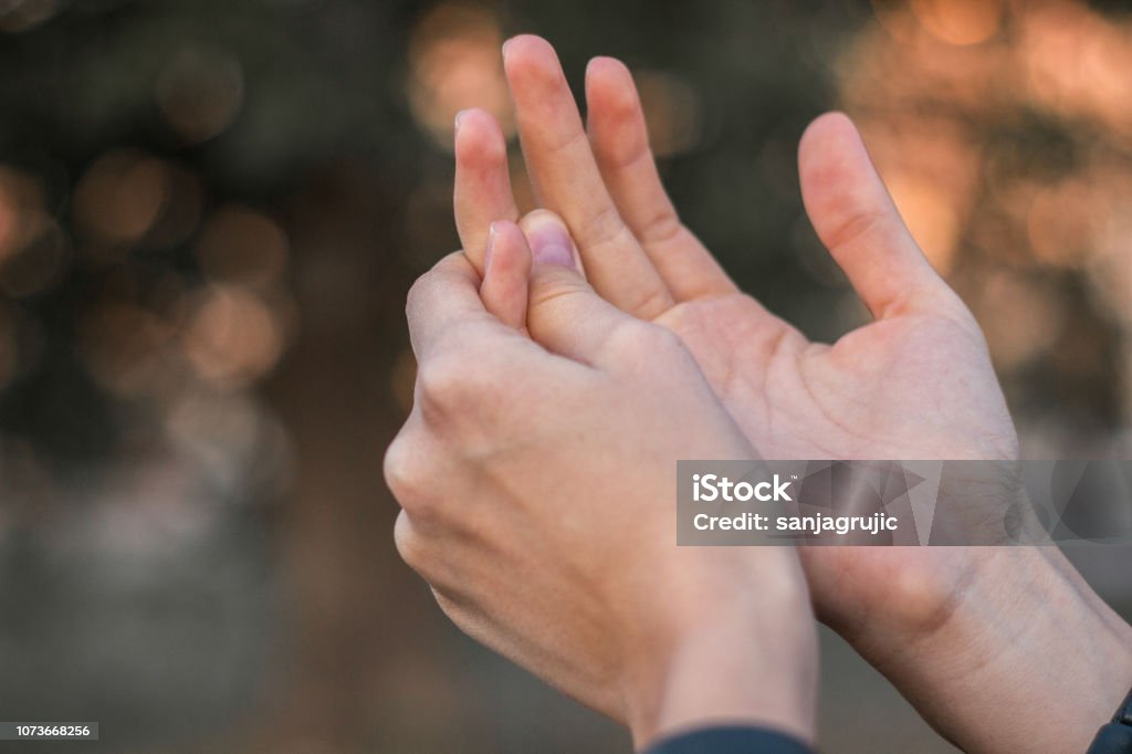 Young woman with pain on finger Young woman with pain on finger, bokeh background Hand Stock Photo
