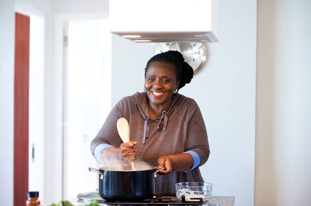 starsza kobieta przygotowująca tradycyjną pap na kuchence gazowej - africa african descent cooking african culture zdjęcia i obrazy z banku zdjęć