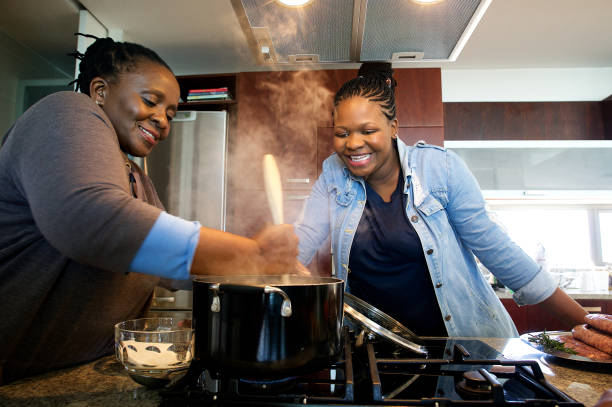 matka i córka przygotowują tradycyjne pap razem w kuchennym piecu gazowym - africa african descent cooking african culture zdjęcia i obrazy z banku zdjęć