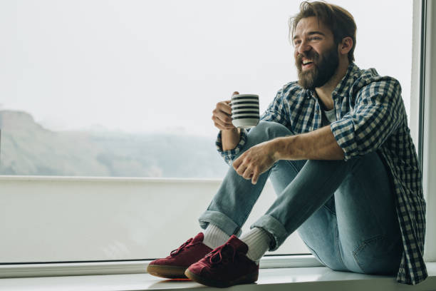 istock Happy man enjoying in his coffee on a window sill. 1073692344