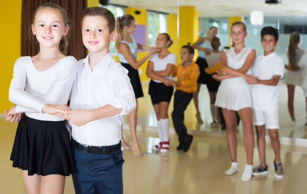 istock Group of smiling children dancing salsa in school 1073692584
