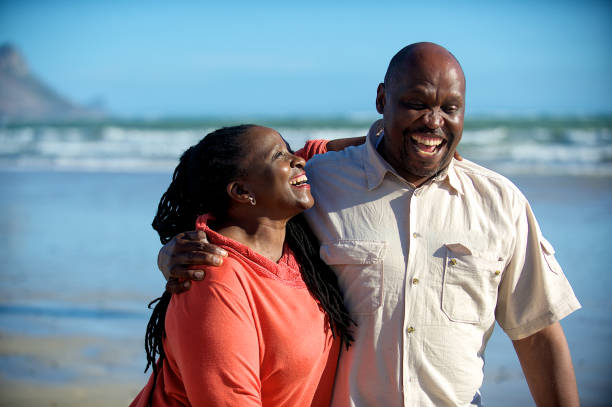 istock Active senior couple walking on the beach having fun together 1073692916