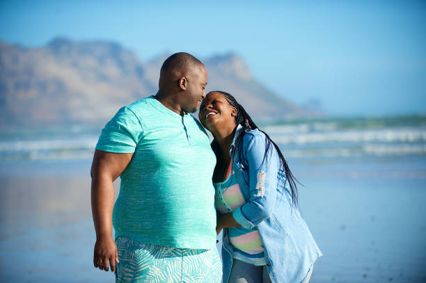 istock Heterosexual African couple walking on the beach 1073692976