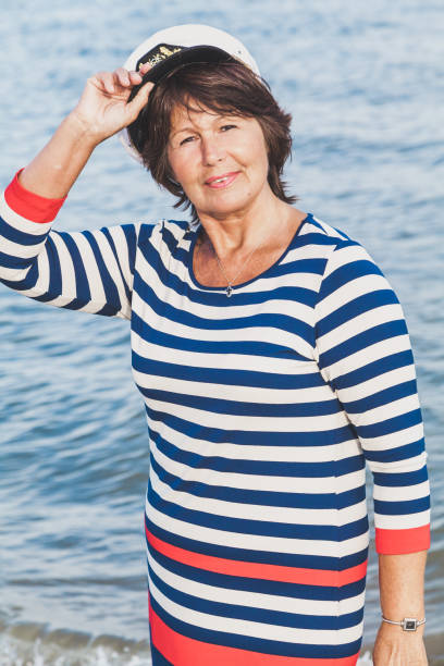 bardzo zadowolony starsza kobieta w kolorze morskim na plaży - cap embroidery blue hat zdjęcia i obrazy z banku zdjęć