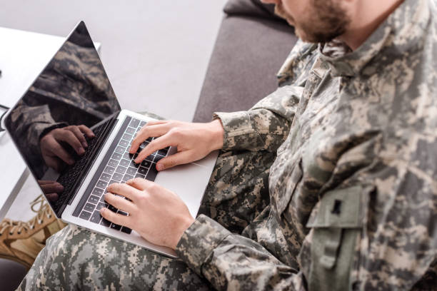 istock partial view of army soldier using laptop on couch 1073699900