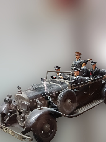 RATINGEN, NRW, GERMANY - AUGUST 17, 2018:
Selective focus views of a model car made of sheet metal with tin soldiers on an exhibition.