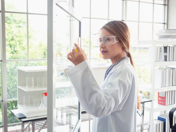 istock asian scientist writes a formula on a glass Board 1073710898