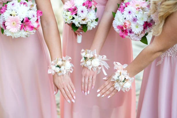 istock Glorious bridesmaids in pink dresses holding beautiful flowers - selective focus 1073716144