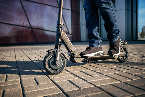 Cerrar vista de las piernas del hombre en el scooter eléctrico photo