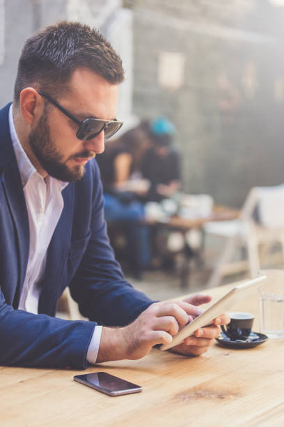 portrait of handsome businessman holding digital tablet in cafe. - hipster people surfing the net internet imagens e fotografias de stock