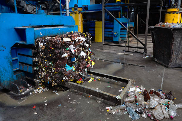 istock Modern waste sorting and recycling plant, hydraulic press makes wired bale from pressed PET bottles for processing and reuse of plastic. Concept of defence of environment by materials reuse 1073717466