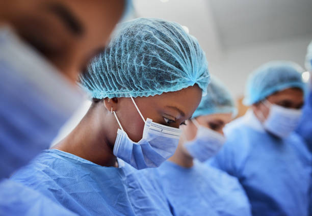 Focused on saving a life Cropped shot of a group of medical professionals performing surgery in the operating theatre sports team event stock pictures, royalty-free photos & images