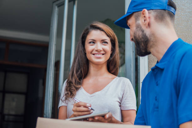 istock Smiling young woman looking at the delivery guy 1073737548