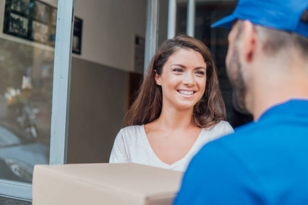 istock Woman looking at delivery man and smiling 1073737720