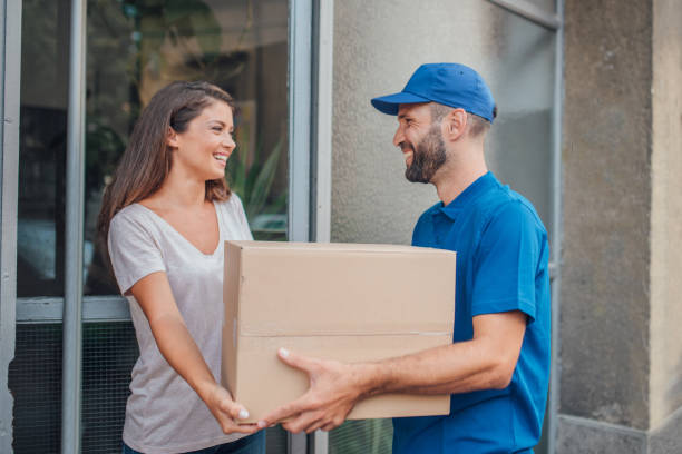 istock Woman taking package from delivery man while smiling to him 1073738746