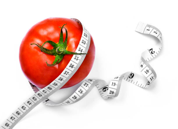 カーリー メジャー テープとトマトのダイエット - instrument of measurement vegetable measuring exercising ストックフォトと画像