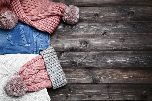 istock Folded sweater with jeans, hat and scarf on wooden table 1073756678