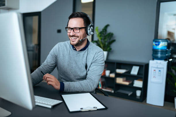 istock Portrait of a handsome smiling man with headset working on the computer. 1073757254