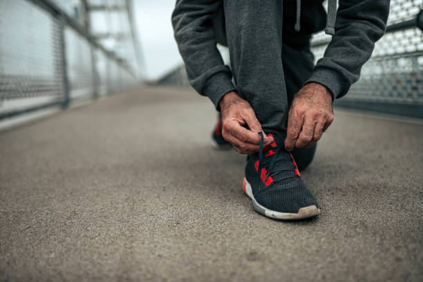 istock Close-up image of senior runner tying shoelaces. 1073759134