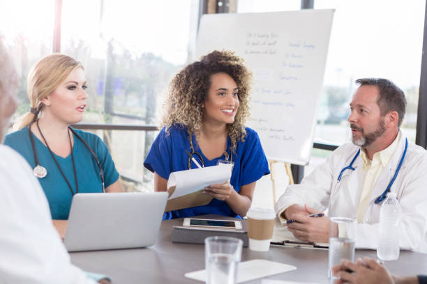 istock Cheerful doctor takes notes during staff meeting 1073771272
