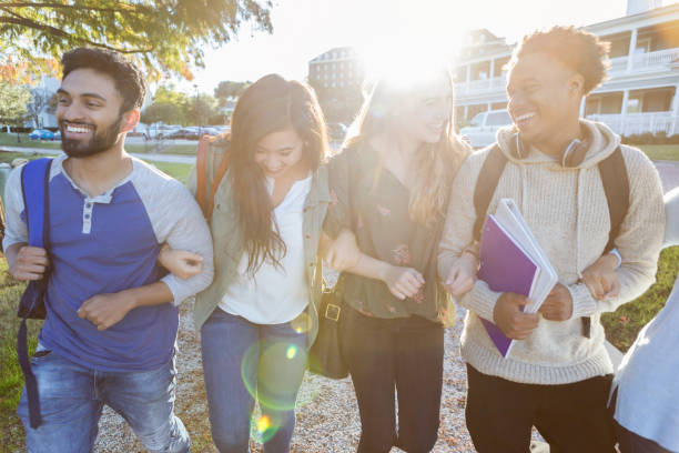 istock Group of college students walk side by side outdoors 1073772936