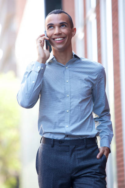 istock smiling businessman walking outside with cellphone 1073774838