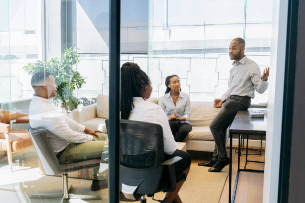 istock Colleagues in meeting room with male manager explaining 1073787572