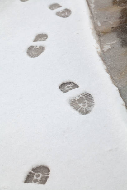 istock Imprint of shoes on white snow 1073790796