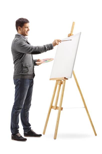 istock Smiling young man painting on a canvas 1073792366