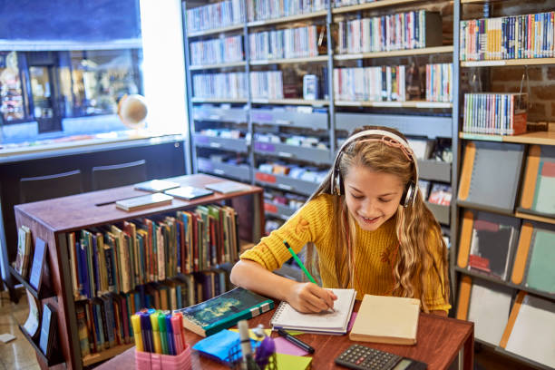 istock little school girl studying in the library 1073801596