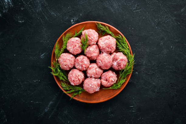 istock Raw meat balls. On a black stone background. Top view. Free copy space. 1073810152