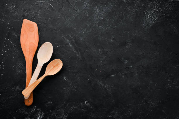 istock Wooden kitchen utensils. On a black stone background. Top view. Free copy space. 1073830106