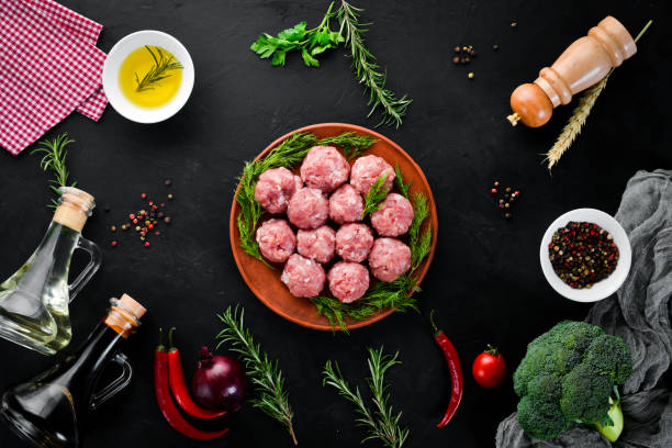 istock Raw meat balls. On a black stone background. Top view. Free copy space. 1073831272