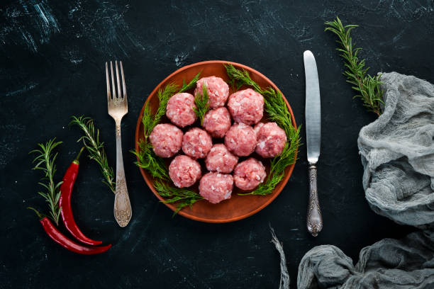 istock Raw meat balls. On a black stone background. Top view. Free copy space. 1073831462