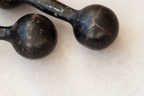 istock Old black dumbbells on a light background, sports background with a copy space 1073840240