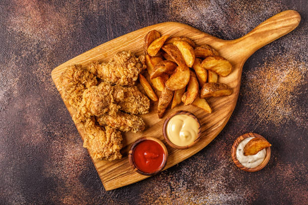 istock Fried chicken wings with fried potato slices 1073841900