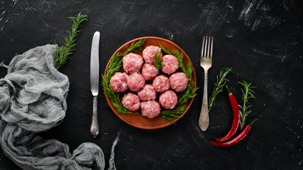 istock Raw meat balls. On a black stone background. Top view. Free copy space. 1073846446