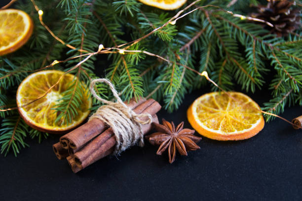 istock Christmas Tree Pine Branches with dry oranges. cinnamon, anise on a dark background. 1073859256