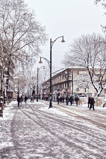 Scenes from everyday street life in Turkey. People walking on a snow covered main street 'Cumhuriyet Caddesi' of Bursa city