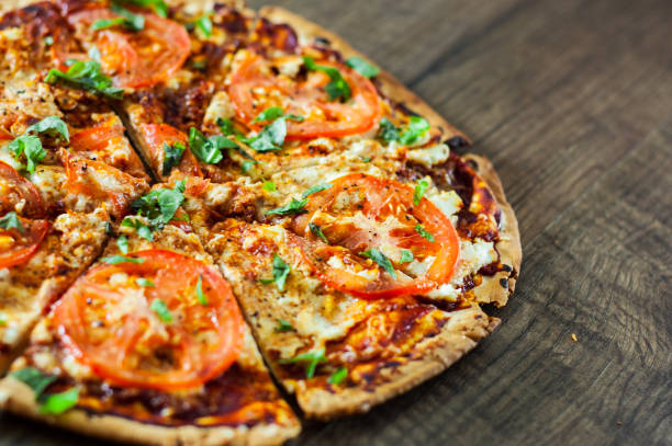 istock Pizza with Mozzarella cheese, Tomatoes, pepper, Spices and Fresh Basil. Italian pizza. Pizza Margherita or Margarita. on wooden background 1073865738