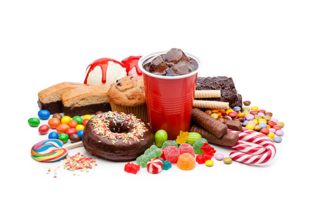 Large group of food with high sugar level isolated on white background High angle view of a large group of multicolored products with high sugar level shot on white background. Food included in the composition are candies, donuts, chocolate bar, a glass of soda, ice cream, muffin and bakery items. High key DSRL studio photo taken with Canon EOS 5D Mk II and Canon EF 100mm f/2.8L Macro IS USM. junk food stock pictures, royalty-free photos & images