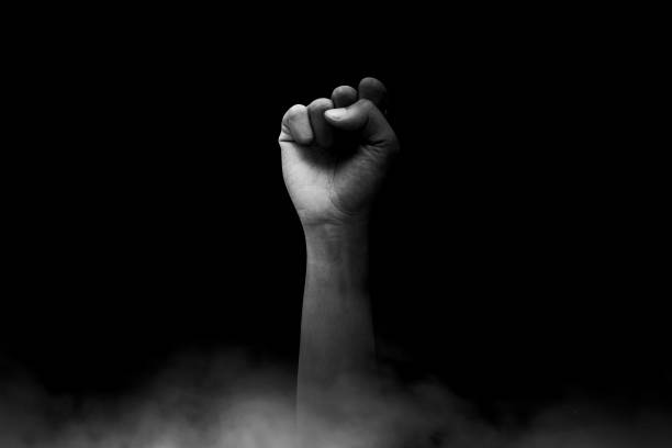 Male clenched fist, isolated on a dark background stock photo