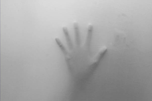 spooky hands behind white cloth. black and white. stock photo