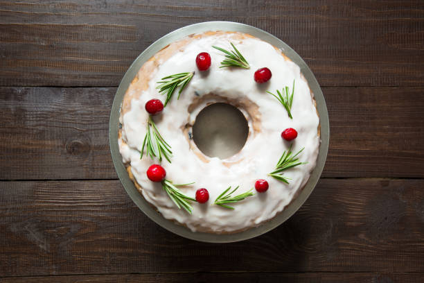 domowe ciasto bożonarodzeniowe z udekorować żurawiną i rozmarynem na ozdobnym talerzu. widok z góry. - christmas cake zdjęcia i obrazy z banku zdjęć